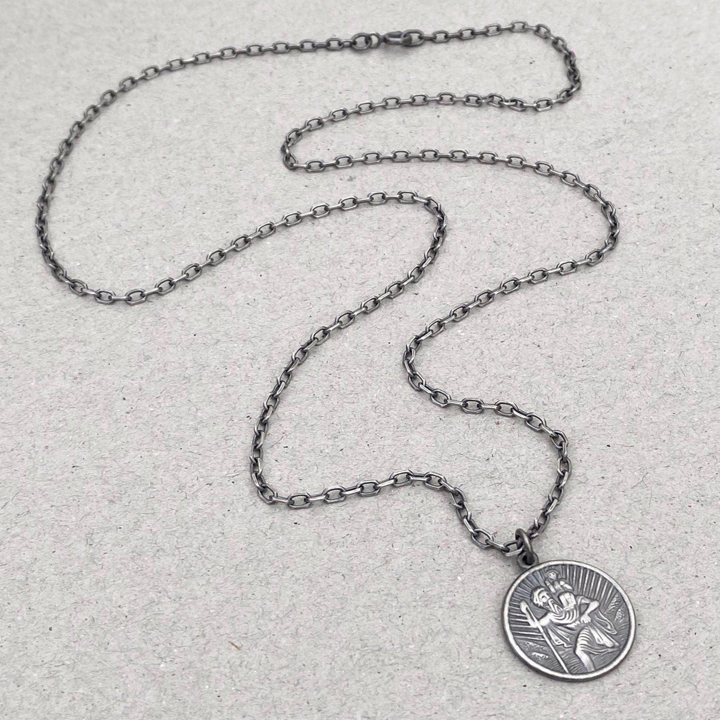 Oxidised or polished solid silver round Saint Christopher pendant on a diamond cut trace chain