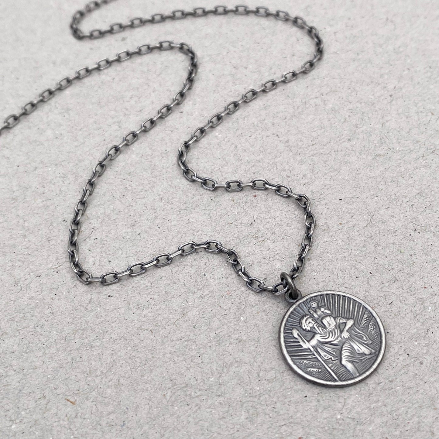 Oxidised or polished solid silver round Saint Christopher pendant on a diamond cut trace chain