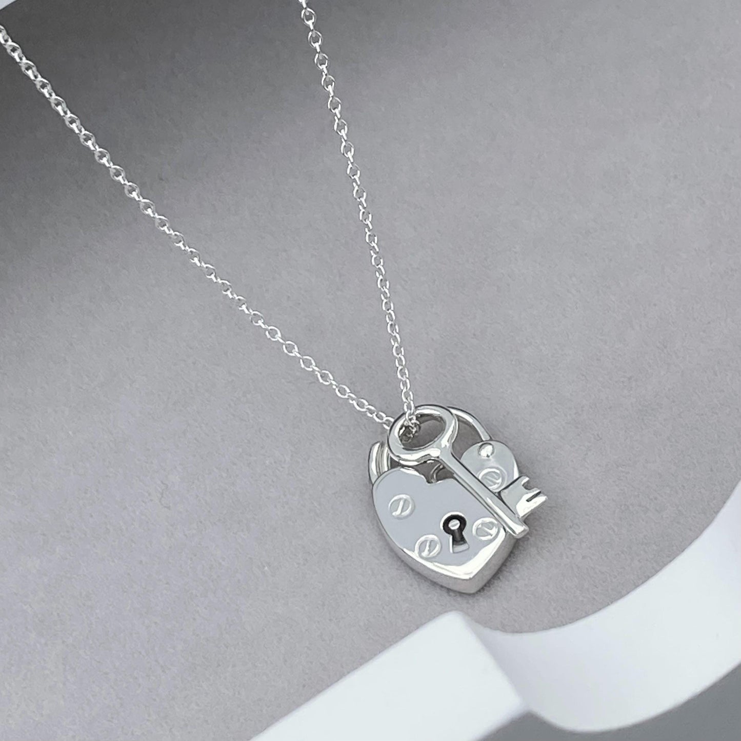 Solid silver heart padlock and dainty key charm pendant on a trace chain