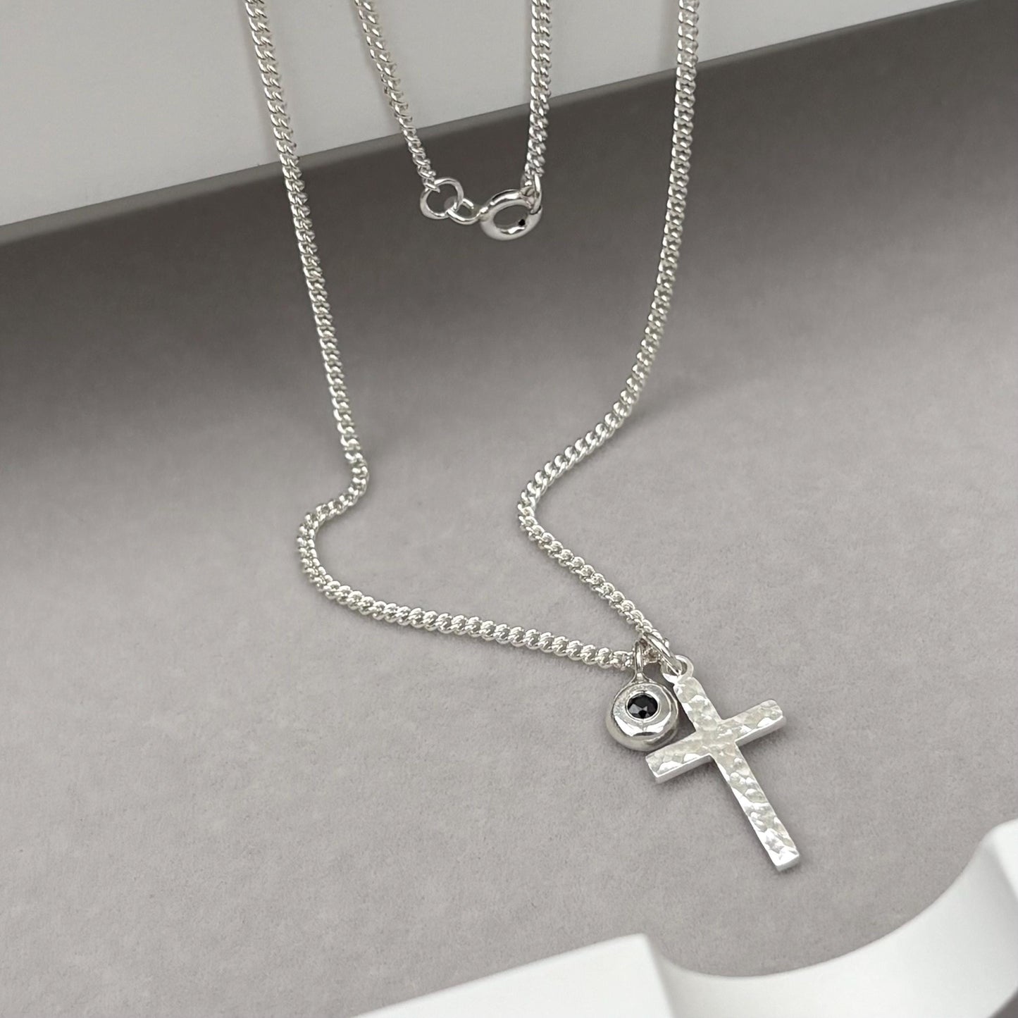 Oxidised or polished small size solid silver hammered cross pendant and black sapphire nugget charm on a curb chain