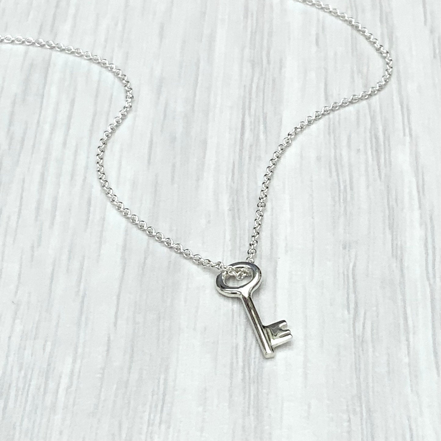 Solid silver small and dainty key charm pendants on a trace chain. A choice of one, two or three key pendants.