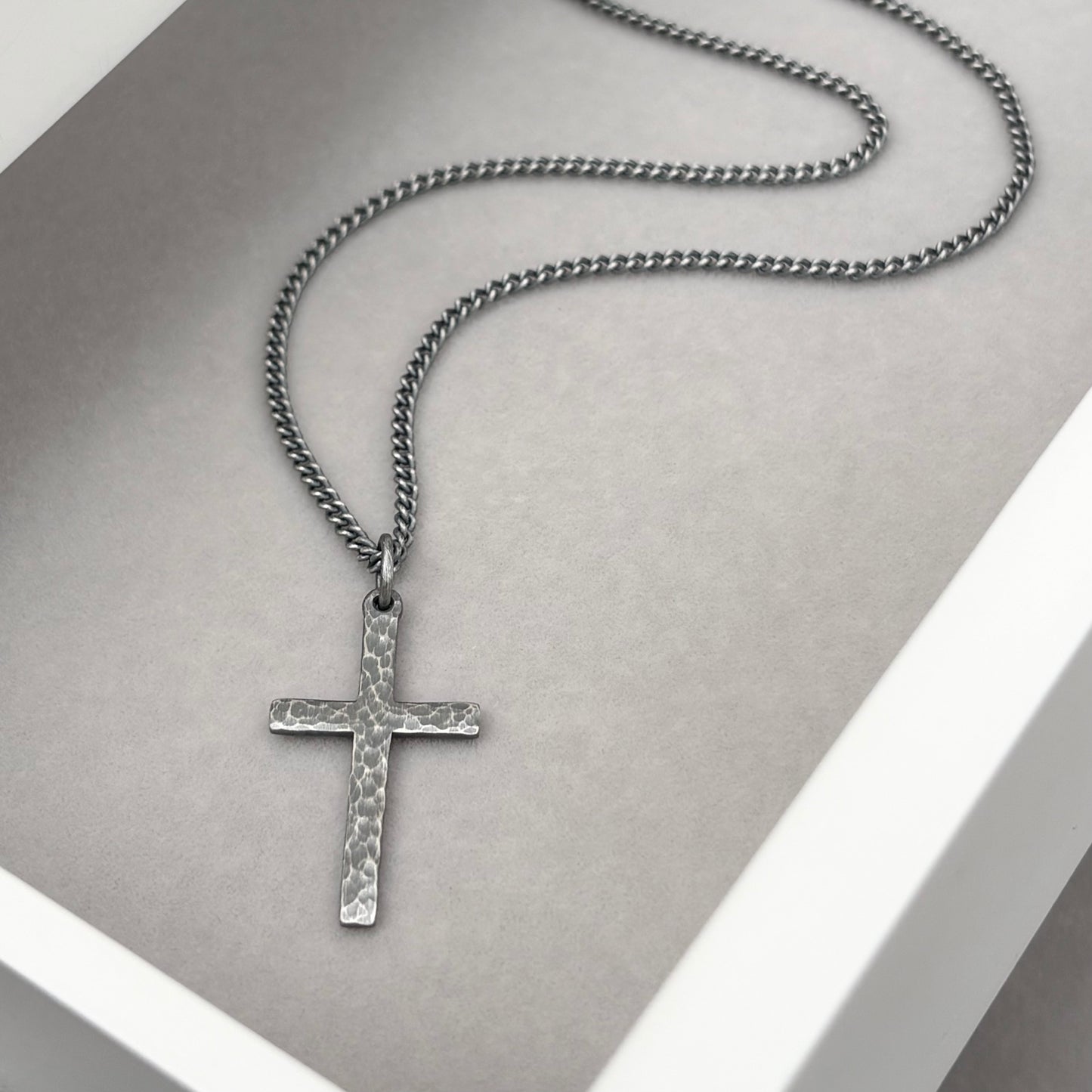 Oxidised sterling silver hammered finish small, standard, and medium cross pendants on a curb chain