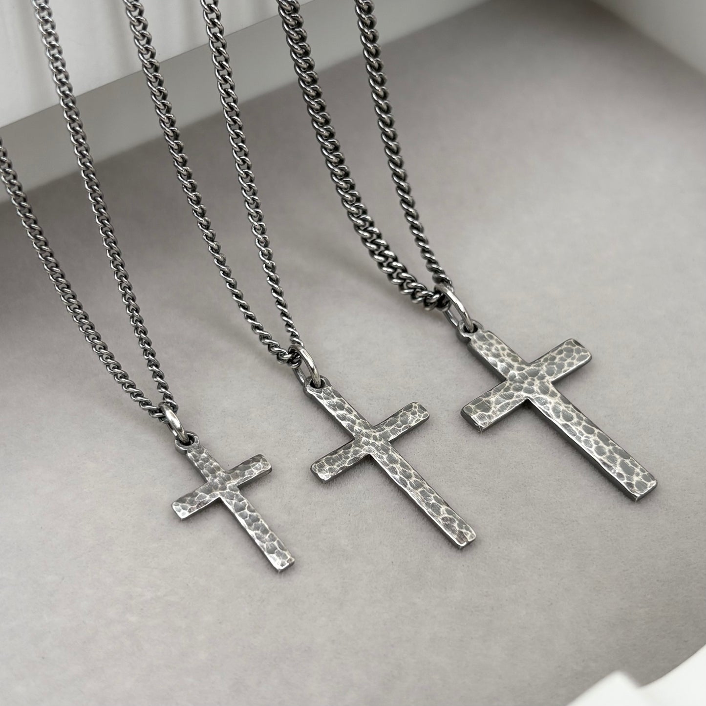 Antiqued sterling silver hammered finish small, standard, and medium cross pendants on a curb chain