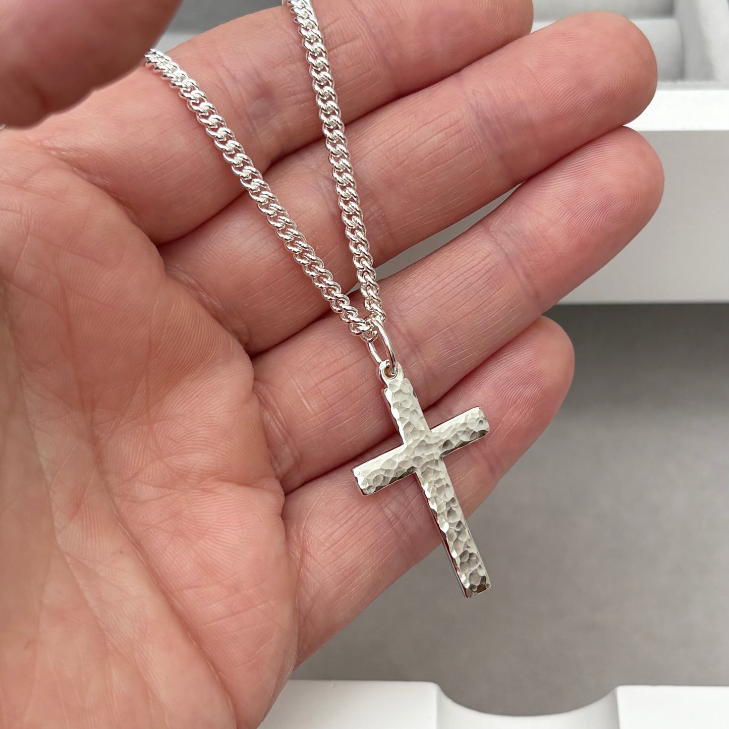 Polished sterling silver hammered finish small, standard, and medium cross pendants on a curb chain