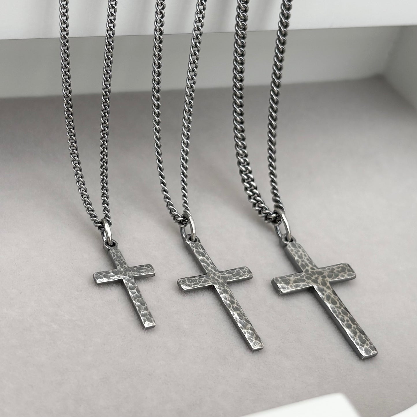 Antiqued sterling silver hammered finish small, standard, and medium cross pendants on a curb chain