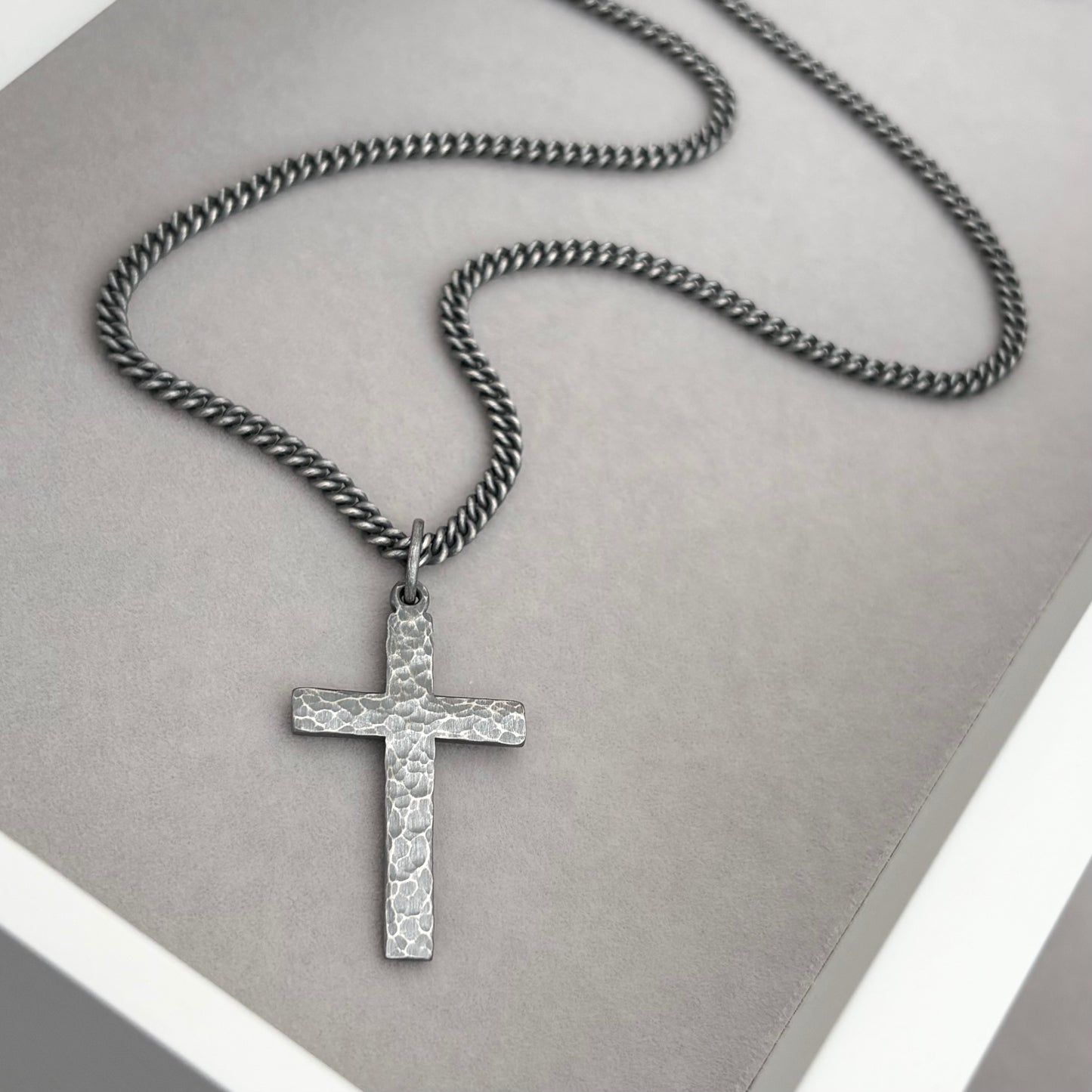 Oxidised sterling silver hammered finish small, standard, and medium cross pendants on a curb chain