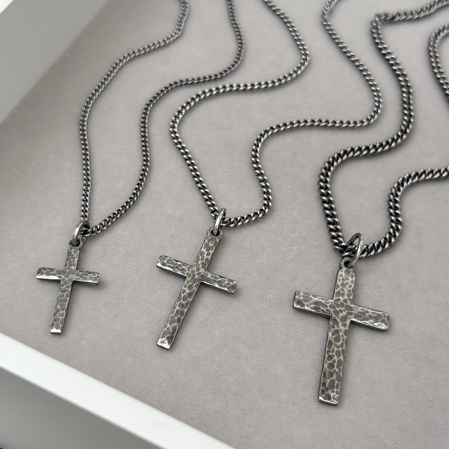 Antiqued sterling silver hammered finish small, standard, and medium cross pendants on a curb chain