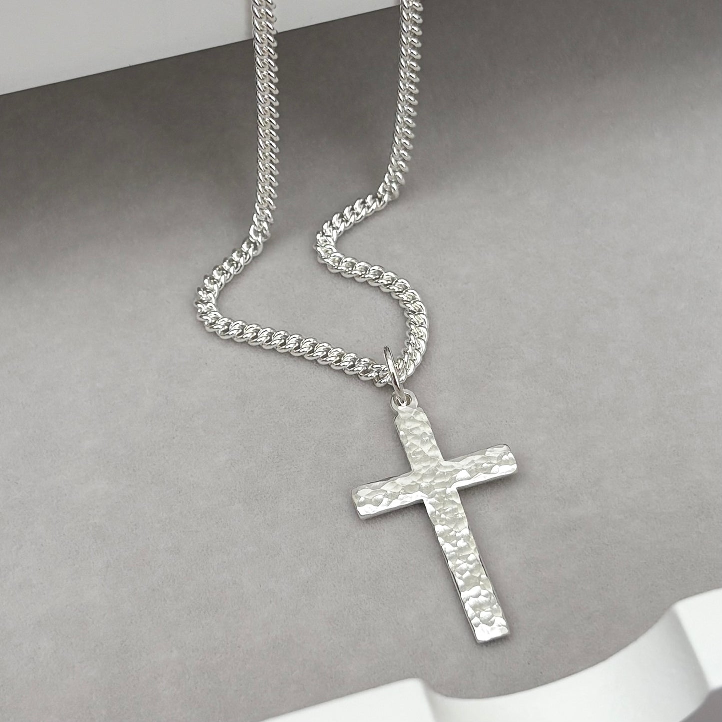 Polished sterling silver hammered finish small, standard, and medium cross pendants on a curb chain