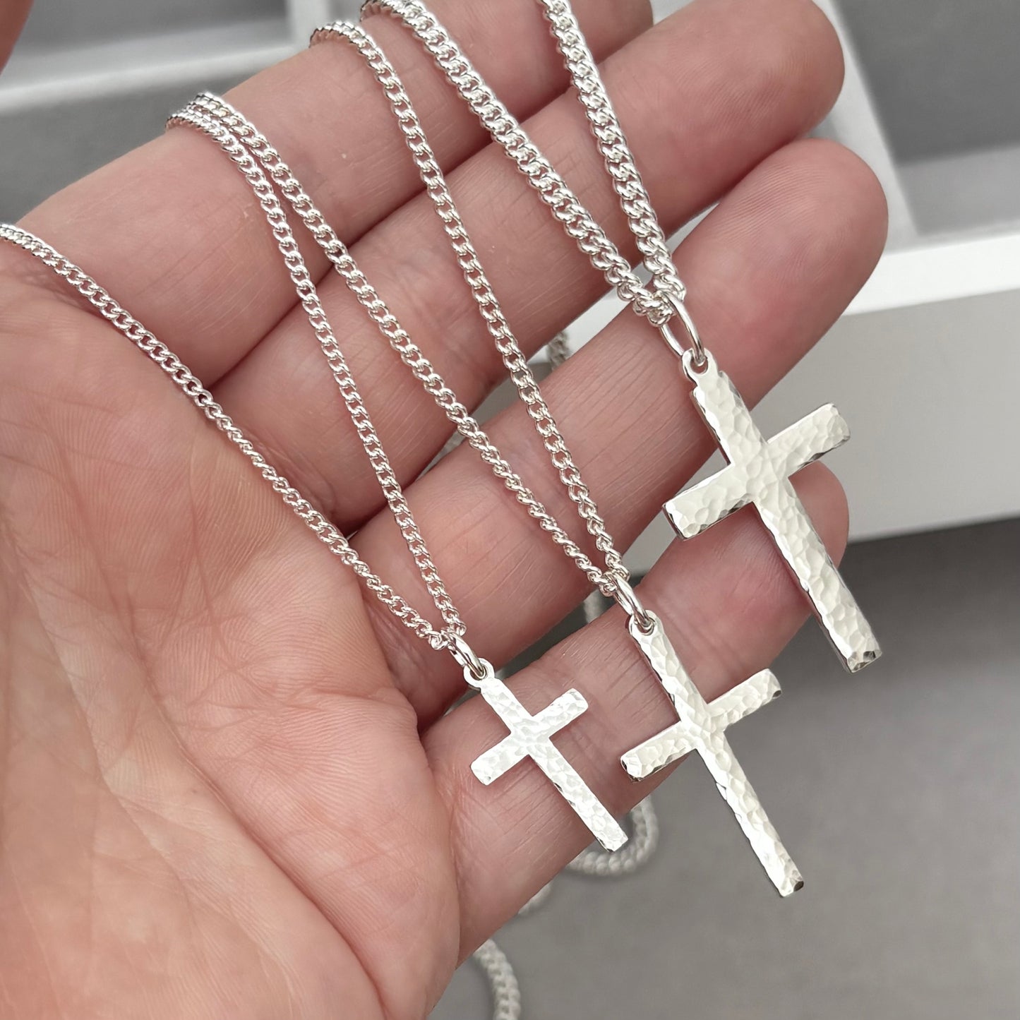 Polished sterling silver hammered finish small, standard, and medium cross pendants on a curb chain