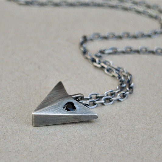 Oxidised solid sterling silver large arrow pendant set with a black sapphire heart on a diamond cut trace chain