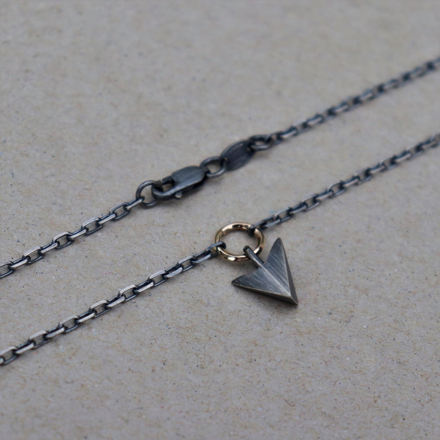 Oxidised or polished solid silver arrow pendant and 9ct yellow gold loop detail on a diamond cut trace chain