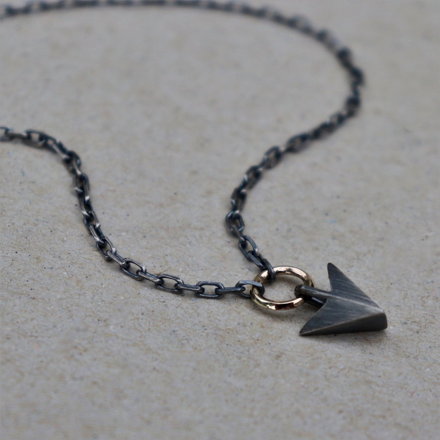 Oxidised or polished solid silver arrow pendant and 9ct yellow gold loop detail on a diamond cut trace chain
