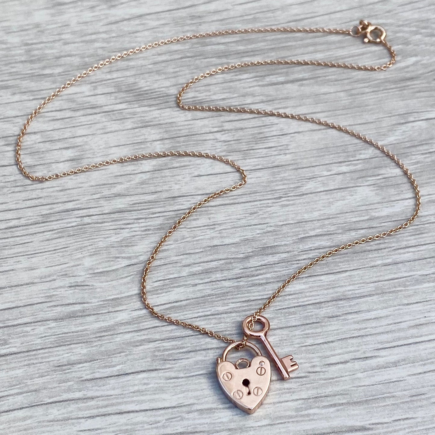 9ct solid rose gold heart padlock and small key charm pendants on a trace chain