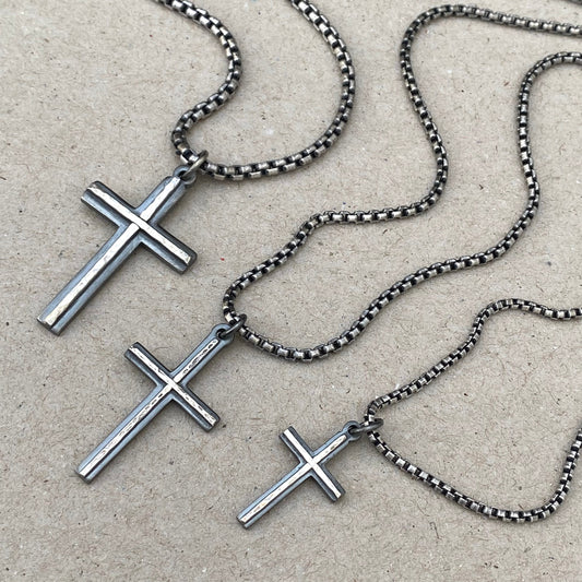 Oxidised solid silver small, standard and medium cross pendants with a polished hammered line detail on a round box chain