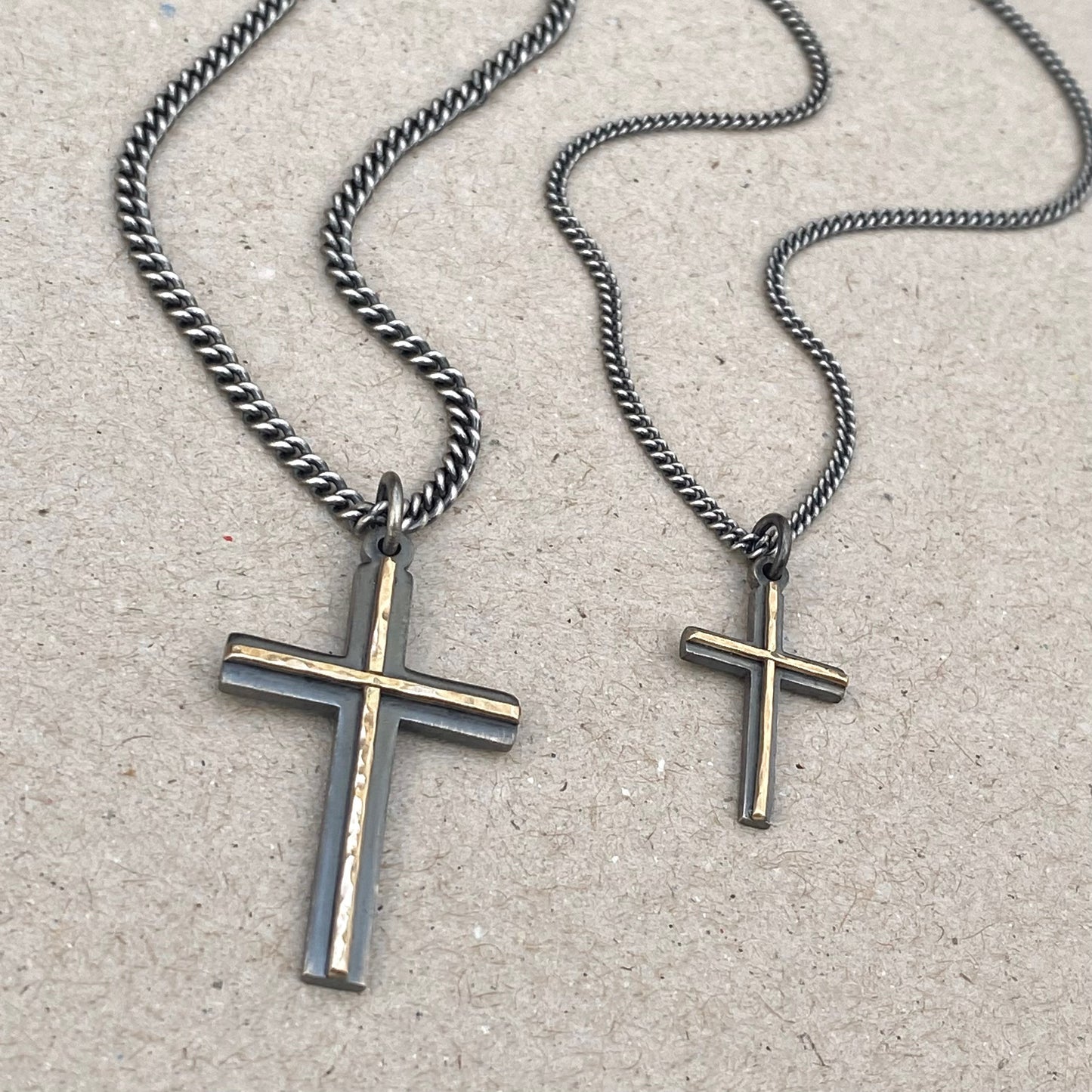 Oxidised solid sterling silver small and medium size cross pendants with a polished hammered 9ct yellow gold line detail on a curb chain