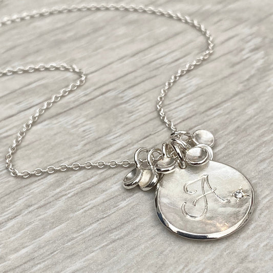 Handmade personalised solid silver 16mm diamond petal charm pendants on a trace chain