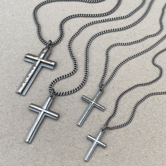 Oxidised solid sterling silver small, standard, medium and large cross pendants with a polished hammered line detail on a curb chain