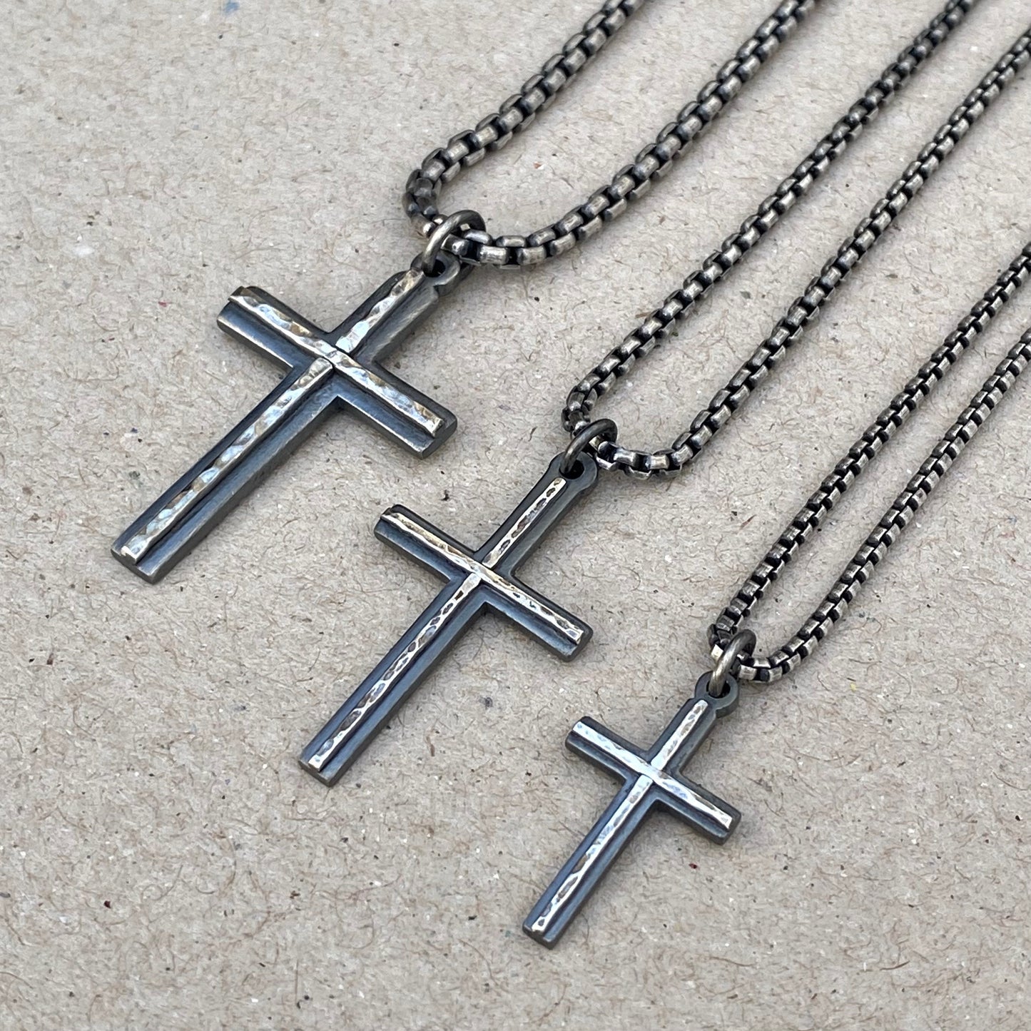 Oxidised solid silver small, standard and medium cross pendants with a polished hammered line detail on a round box chain