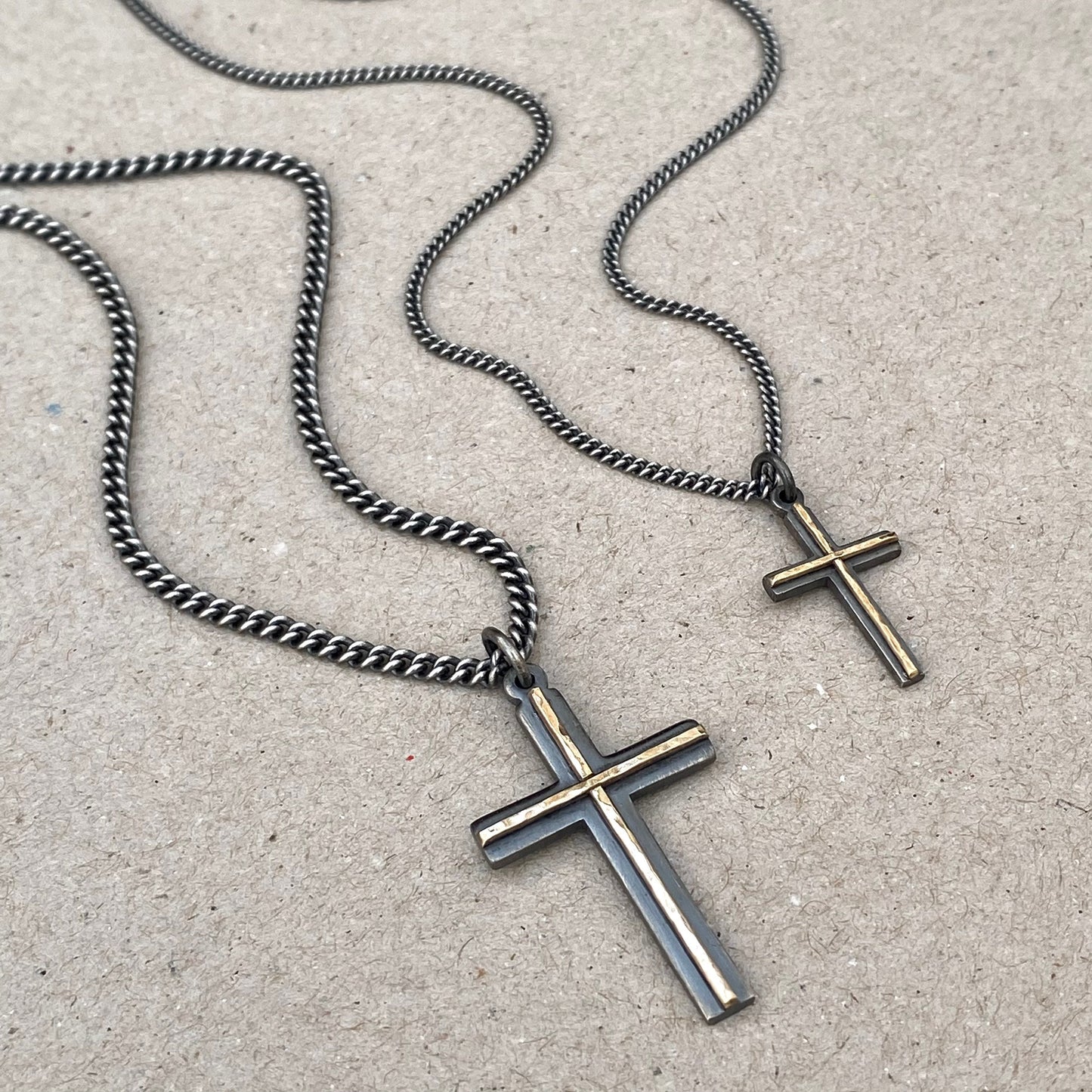 Oxidised solid sterling silver small and medium size cross pendants with a polished hammered 9ct yellow gold line detail on a curb chain
