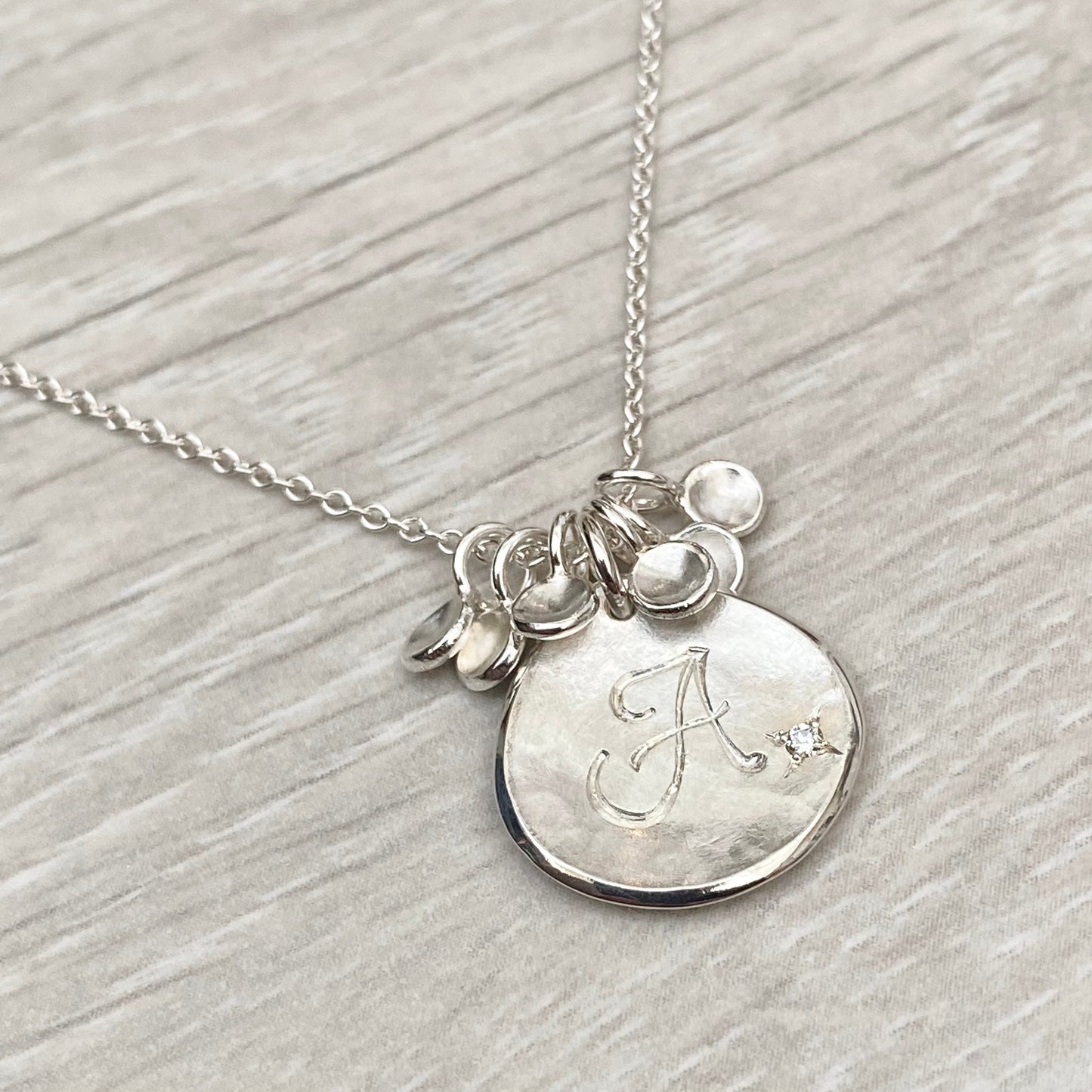 Handmade personalised solid silver 16mm diamond petal charm pendants on a trace chain