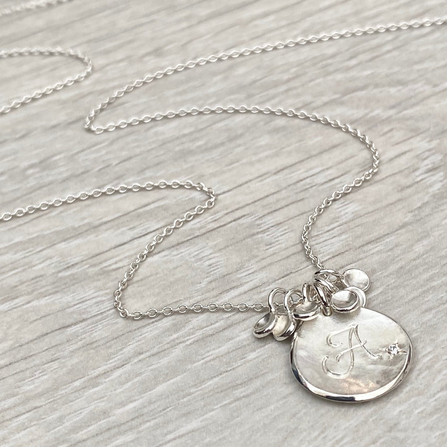 Handmade personalised solid silver 16mm diamond petal charm pendants on a trace chain