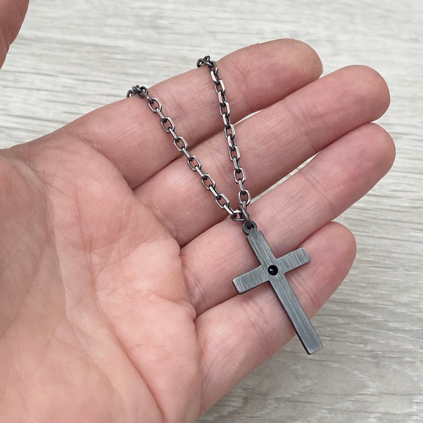 Oxidised solid sterling silver hammered medium size cross with a 9ct yellow gold set black sapphire on a diamond cut trace chain