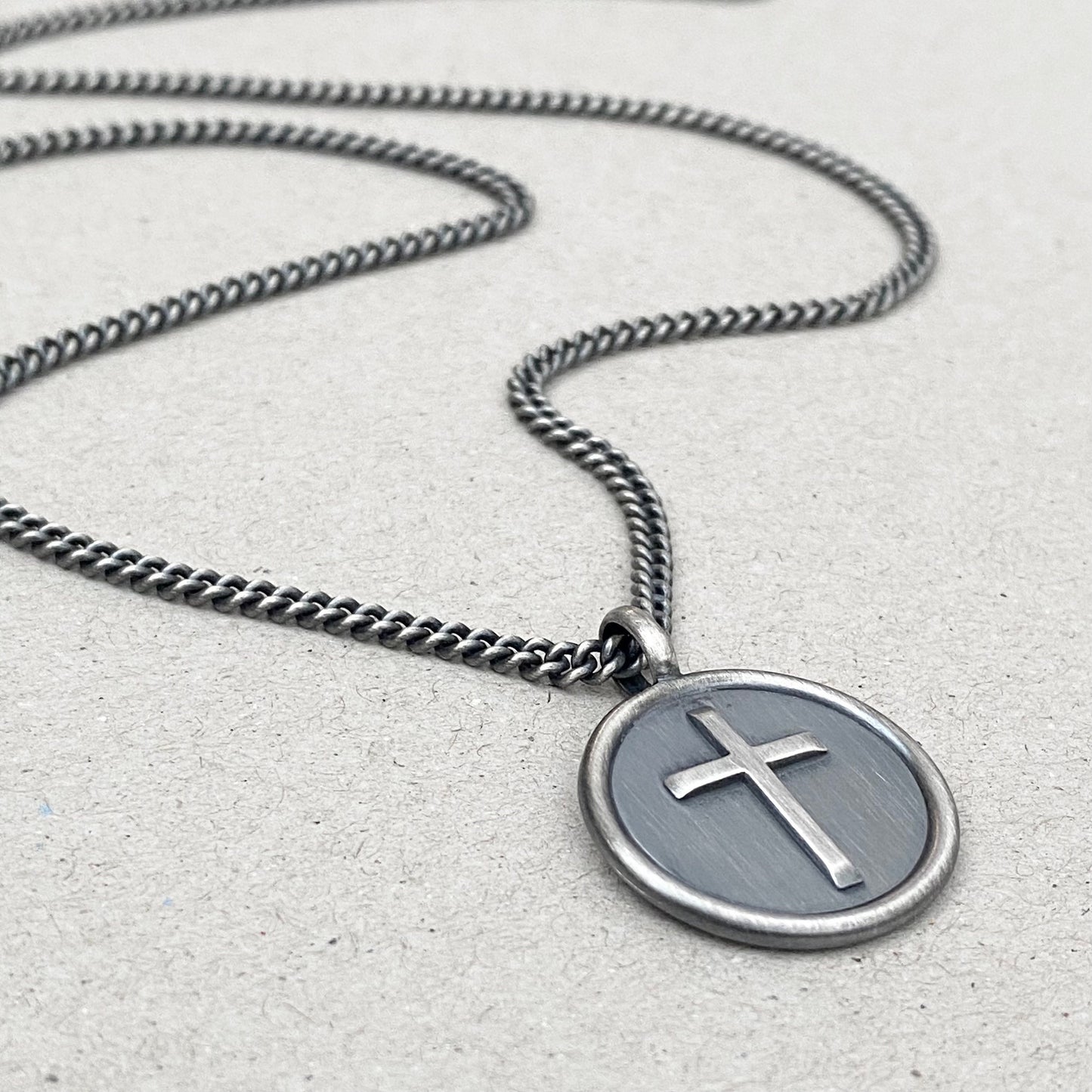 Oxidised solid silver framed circle cross pendant on a curb chain