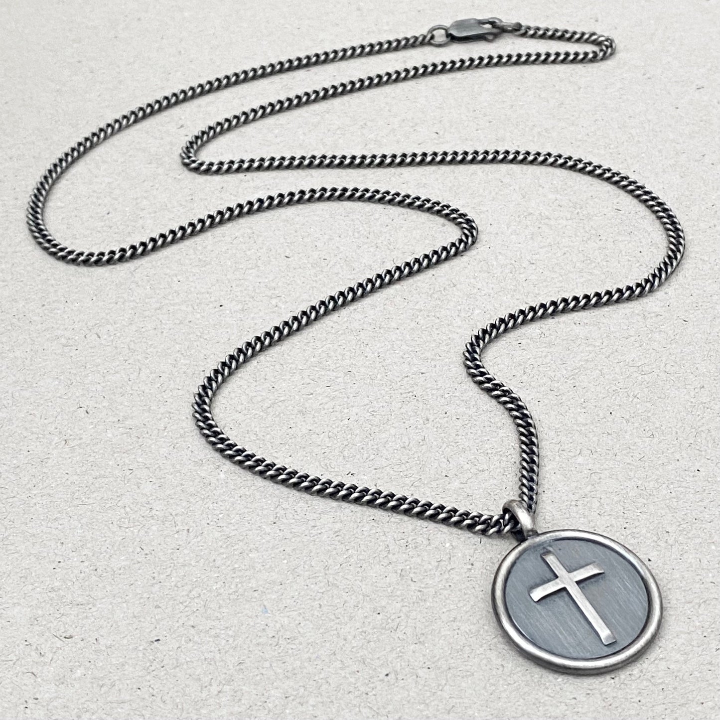 Oxidised solid silver framed circle cross pendant on a curb chain