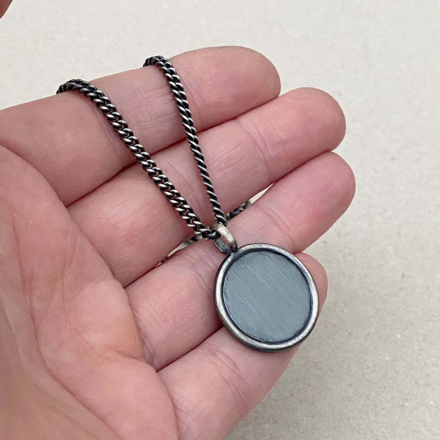 Oxidised solid silver framed circle cross pendant on a curb chain