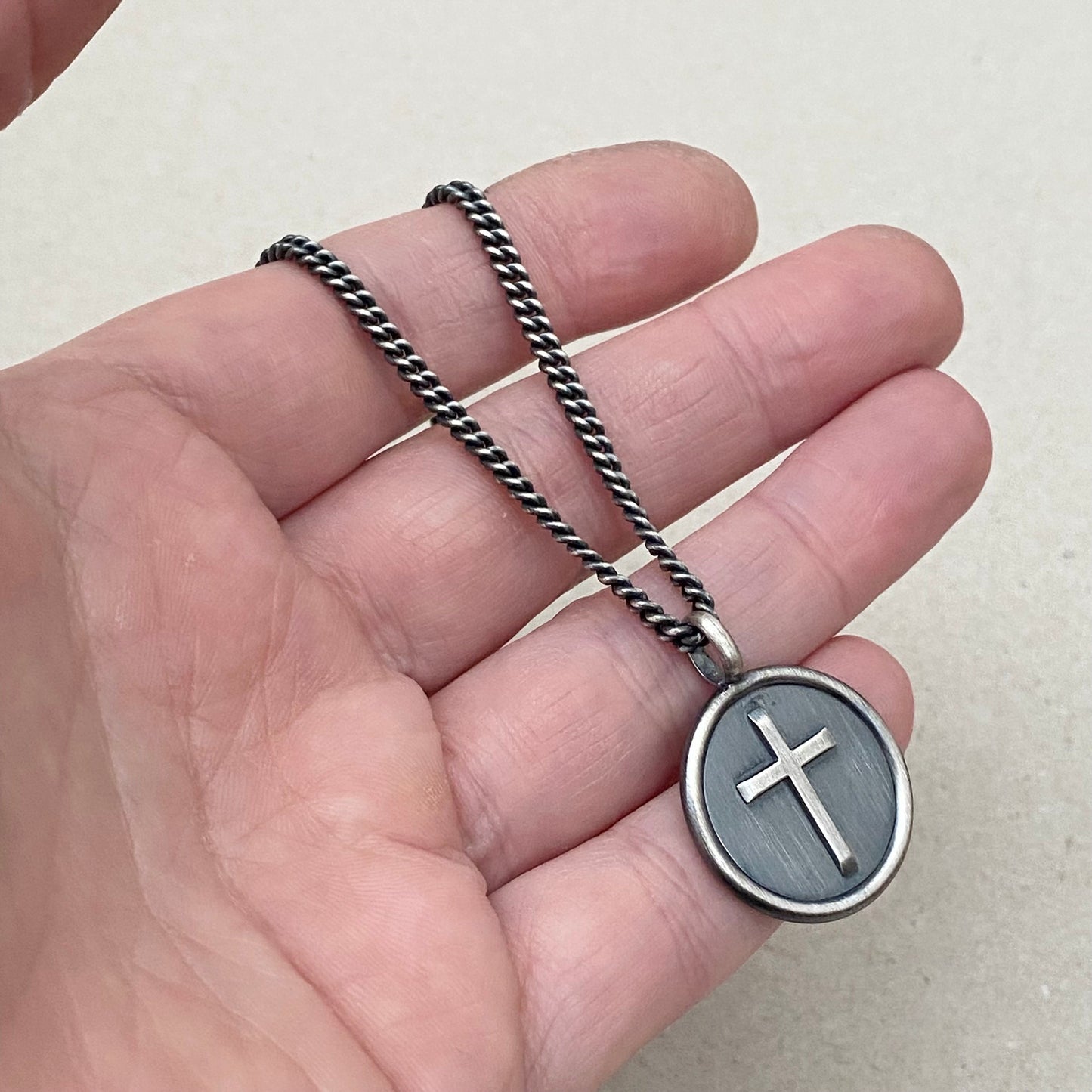 Oxidised solid silver framed circle cross pendant on a curb chain