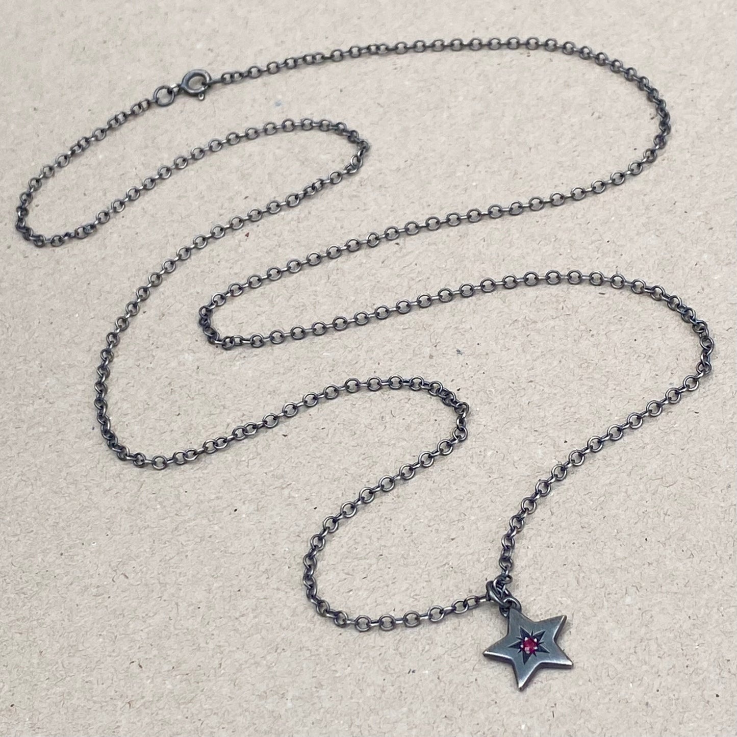 Oxidised silver star engraved birthstone star pendant on a trace chain