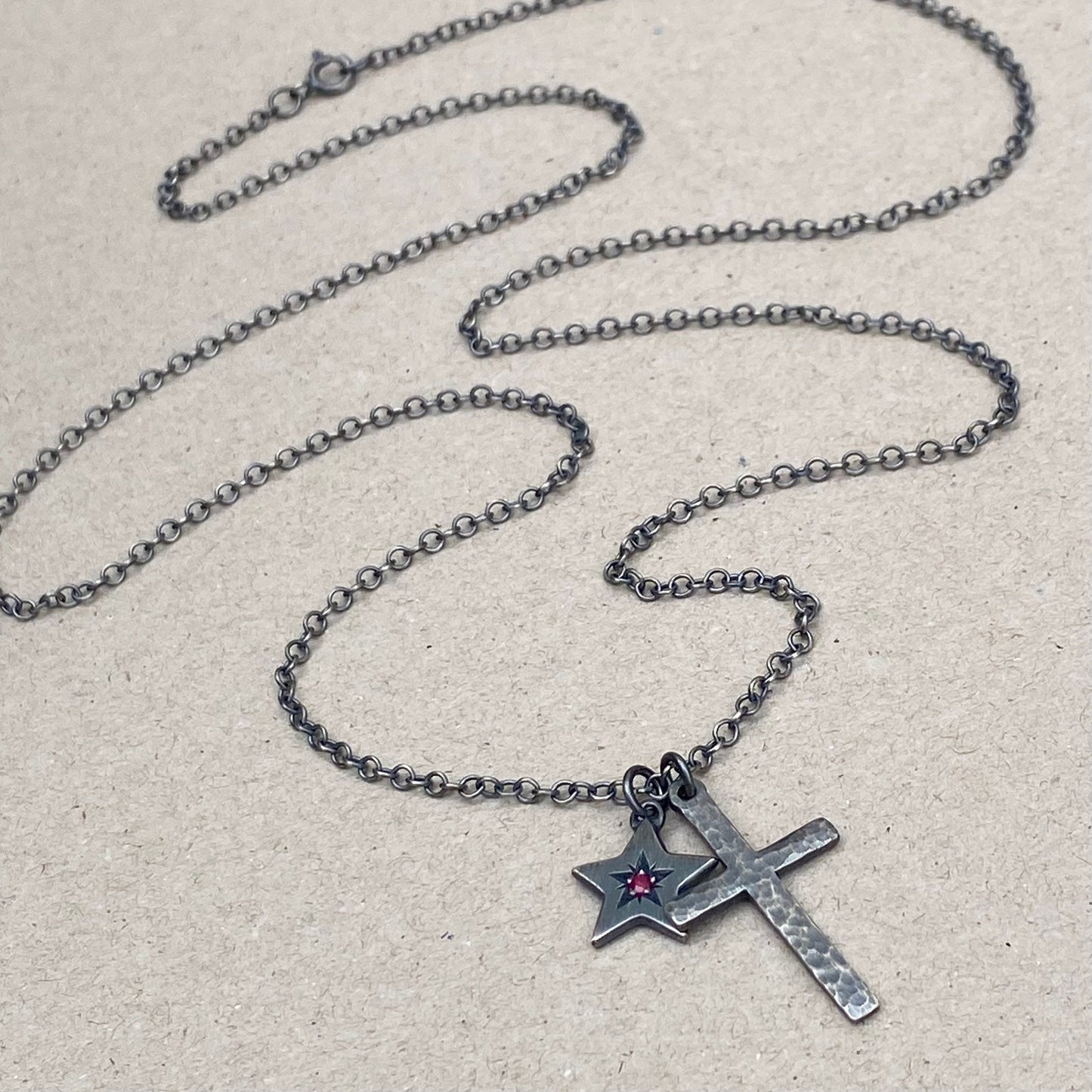 Oxidised silver star engraved birthstone star pendant and hammered cross on a trace chain