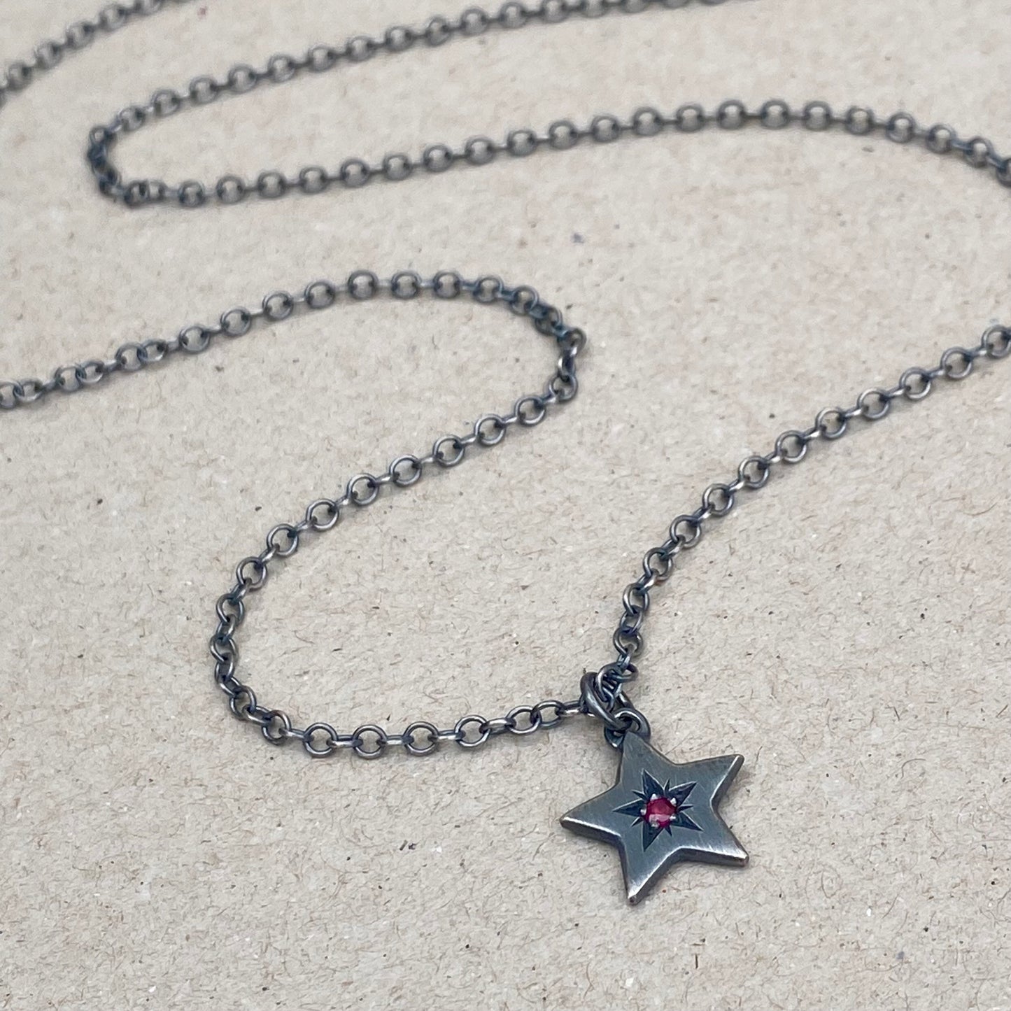 Oxidised silver star engraved birthstone star pendant on a trace chain