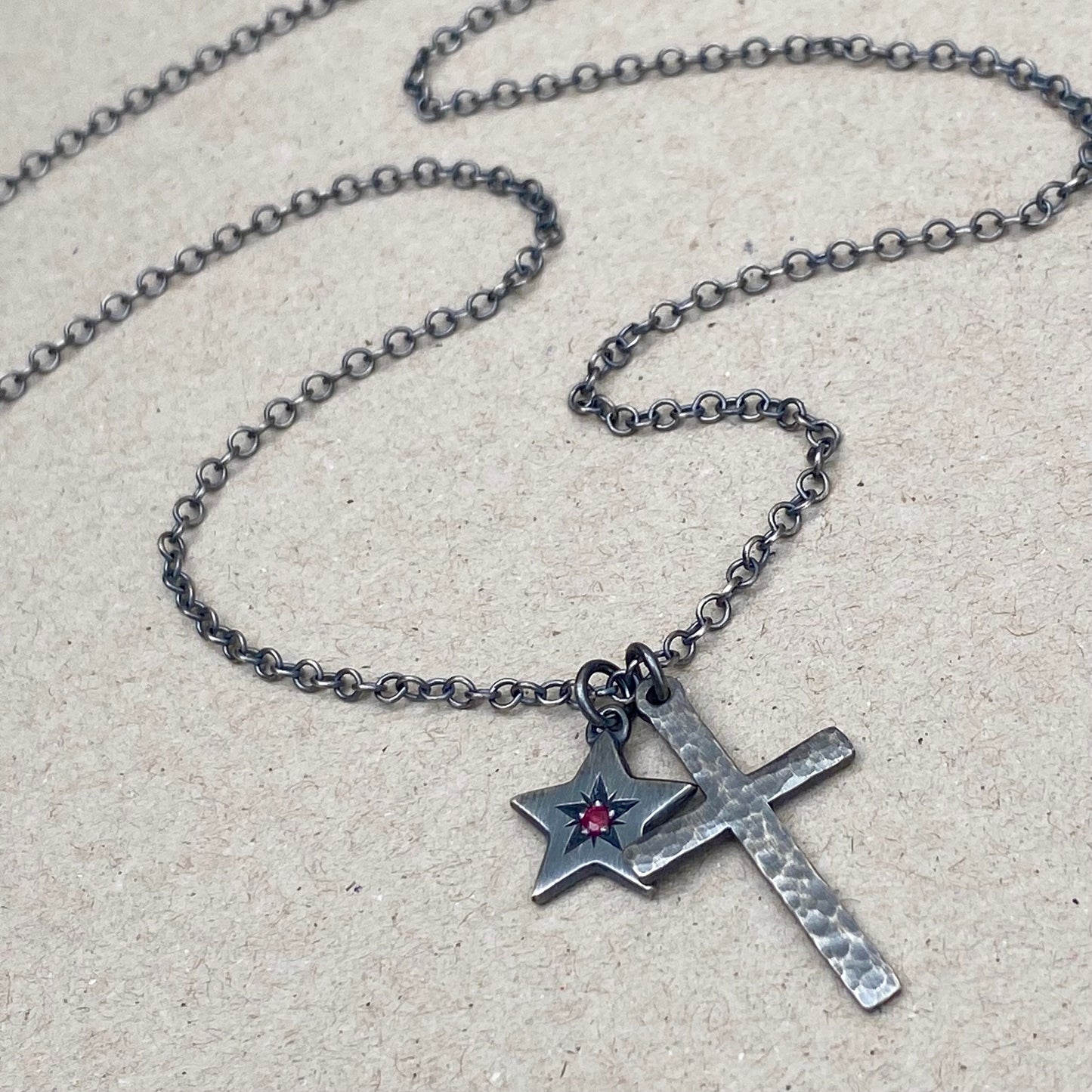 Oxidised silver star engraved birthstone star pendant and hammered cross on a trace chain