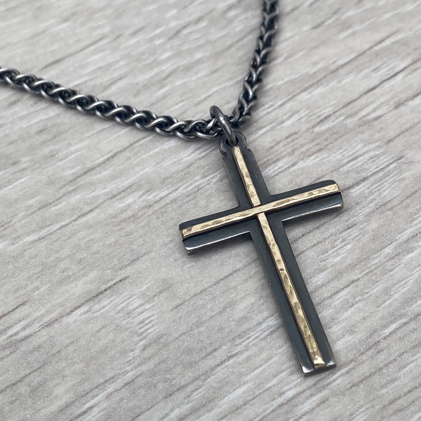 Oxidised solid silver and hammered 9ct yellow gold medium cross pendant on an oxidised silver spiga chain