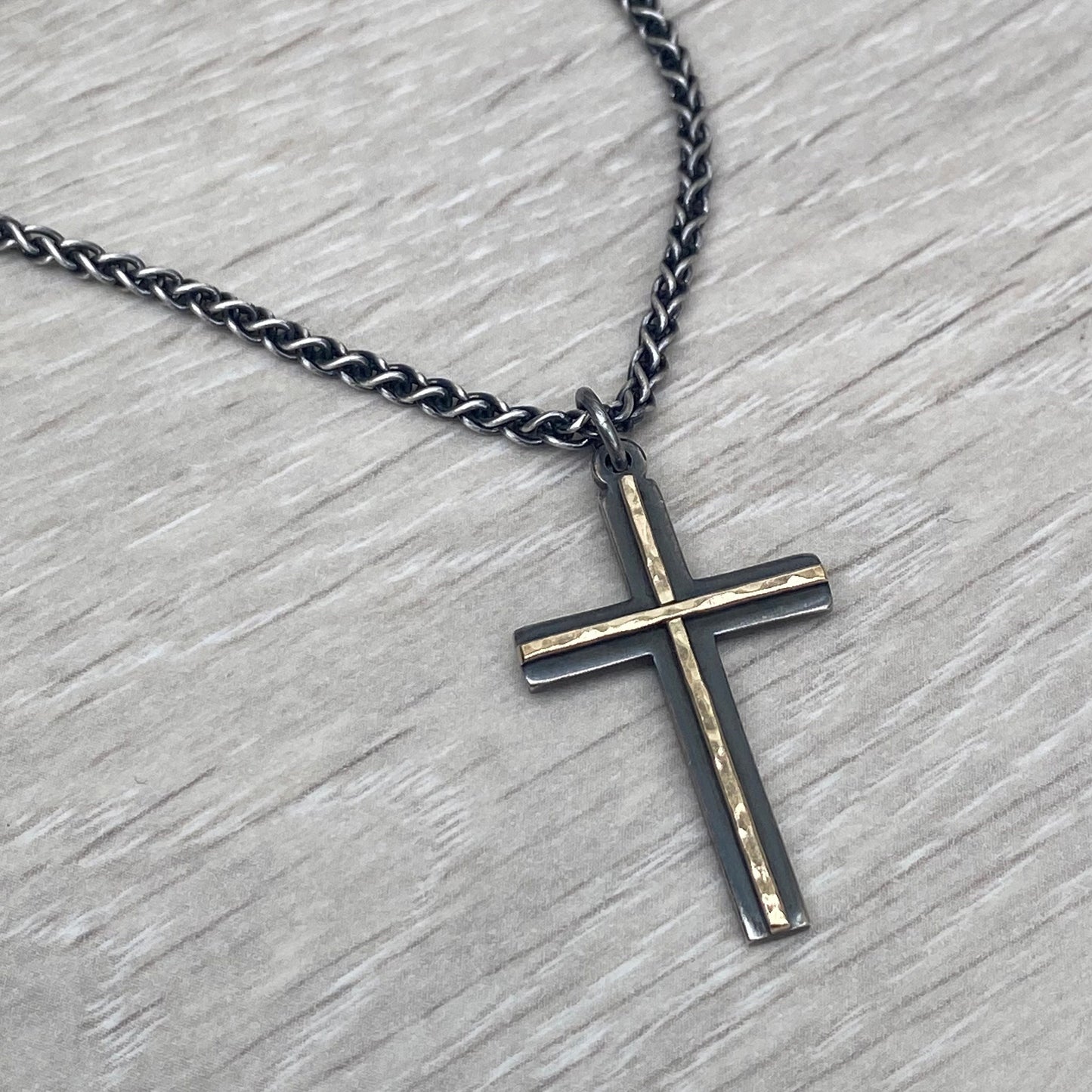 Oxidised solid silver and hammered 9ct yellow gold medium cross pendant on an oxidised silver spiga chain