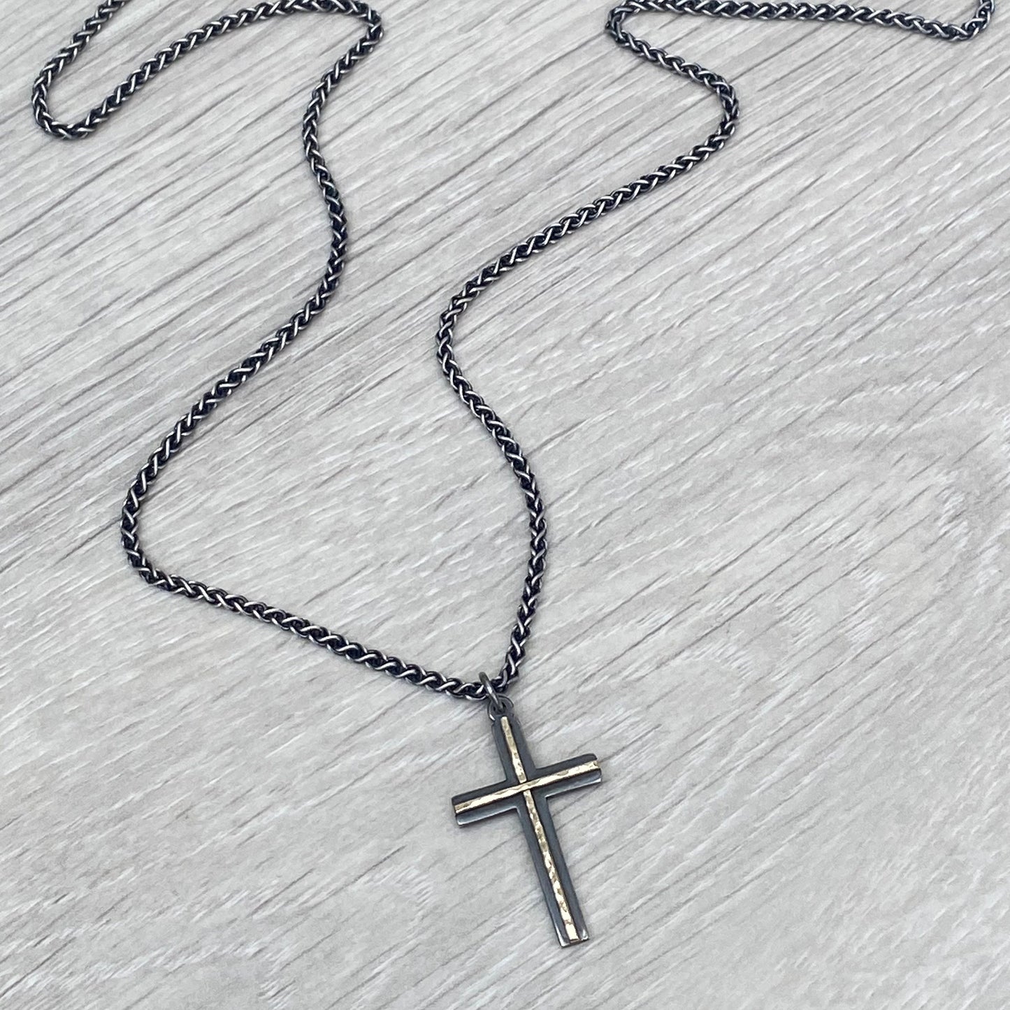 Oxidised solid silver and hammered 9ct yellow gold medium cross pendant on an oxidised silver spiga chain