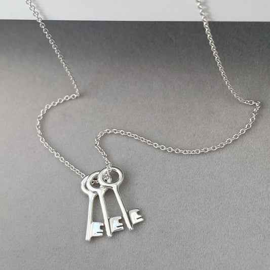 Solid silver small and dainty key charm pendants on a trace chain. A choice of one, two or three keys