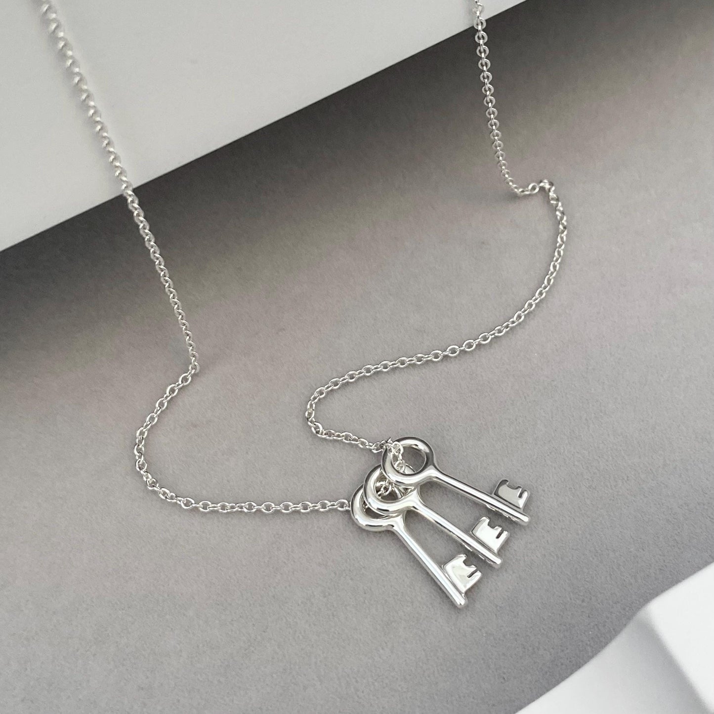 Solid silver small and dainty key charm pendants on a trace chain. A choice of one, two or three keys