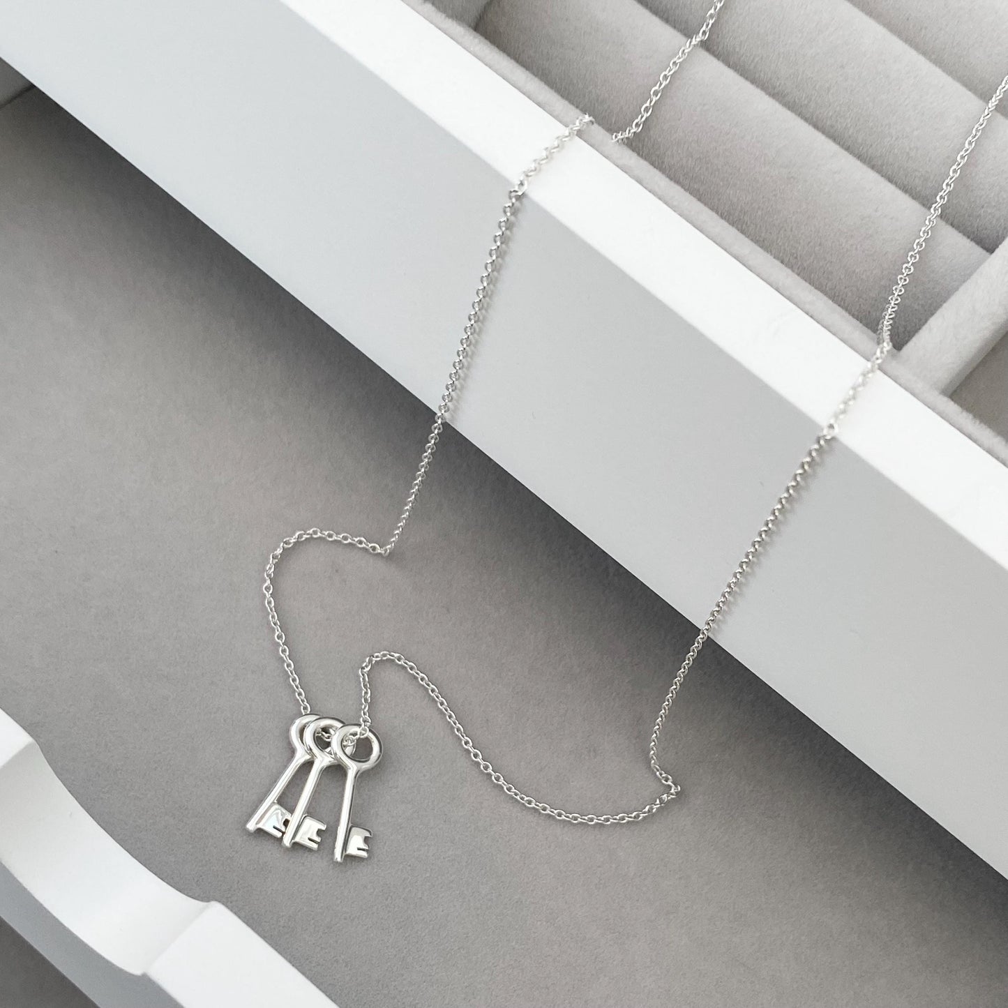 Solid silver small and dainty key charm pendants on a trace chain. A choice of one, two or three keys