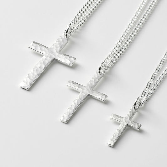 Oxidised or polished solid silver hammered finish small, standard, and medium cross pendants on a curb chain