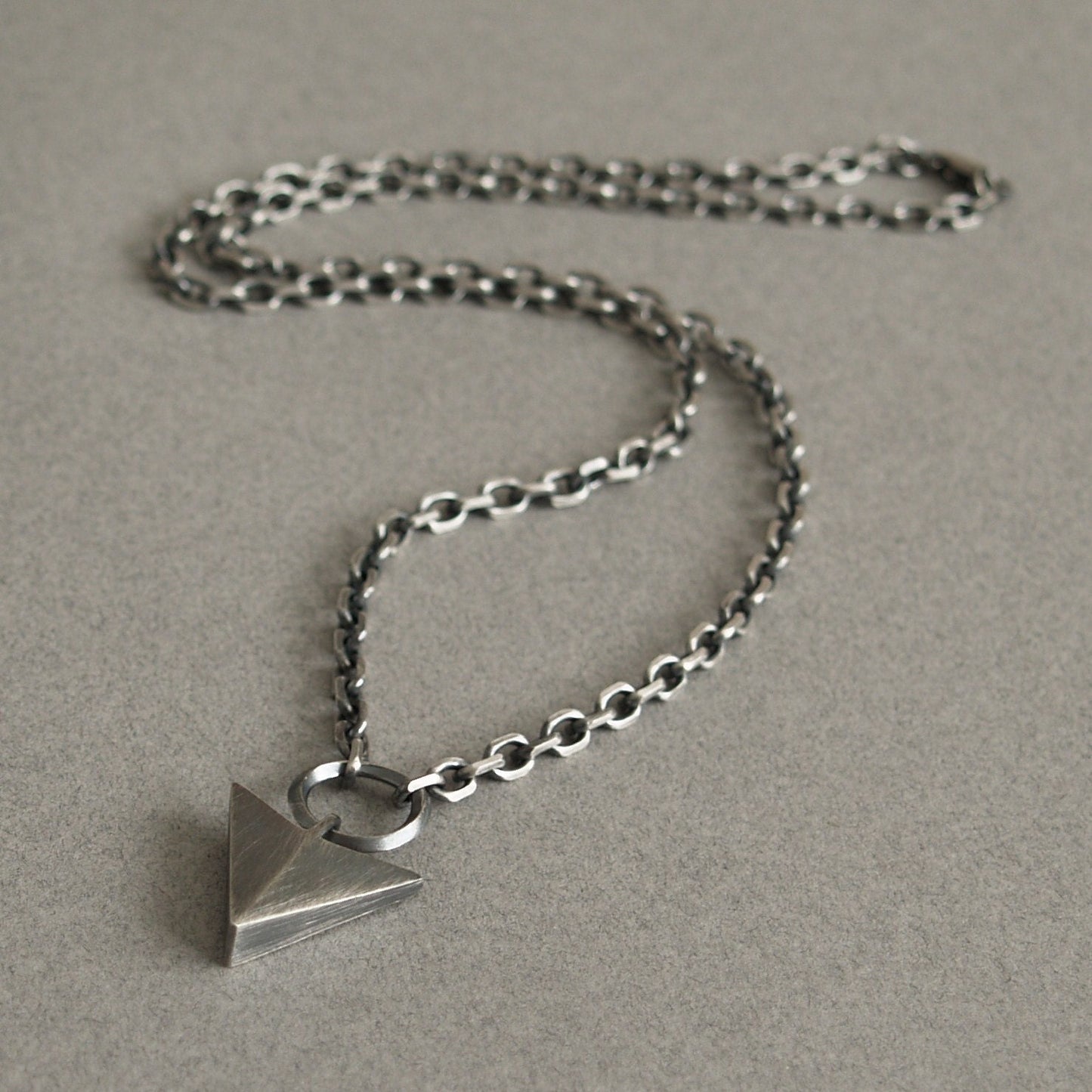 Oxidised or polished solid sterling silver large arrow and loop detail pendant on a diamond cut trace chain