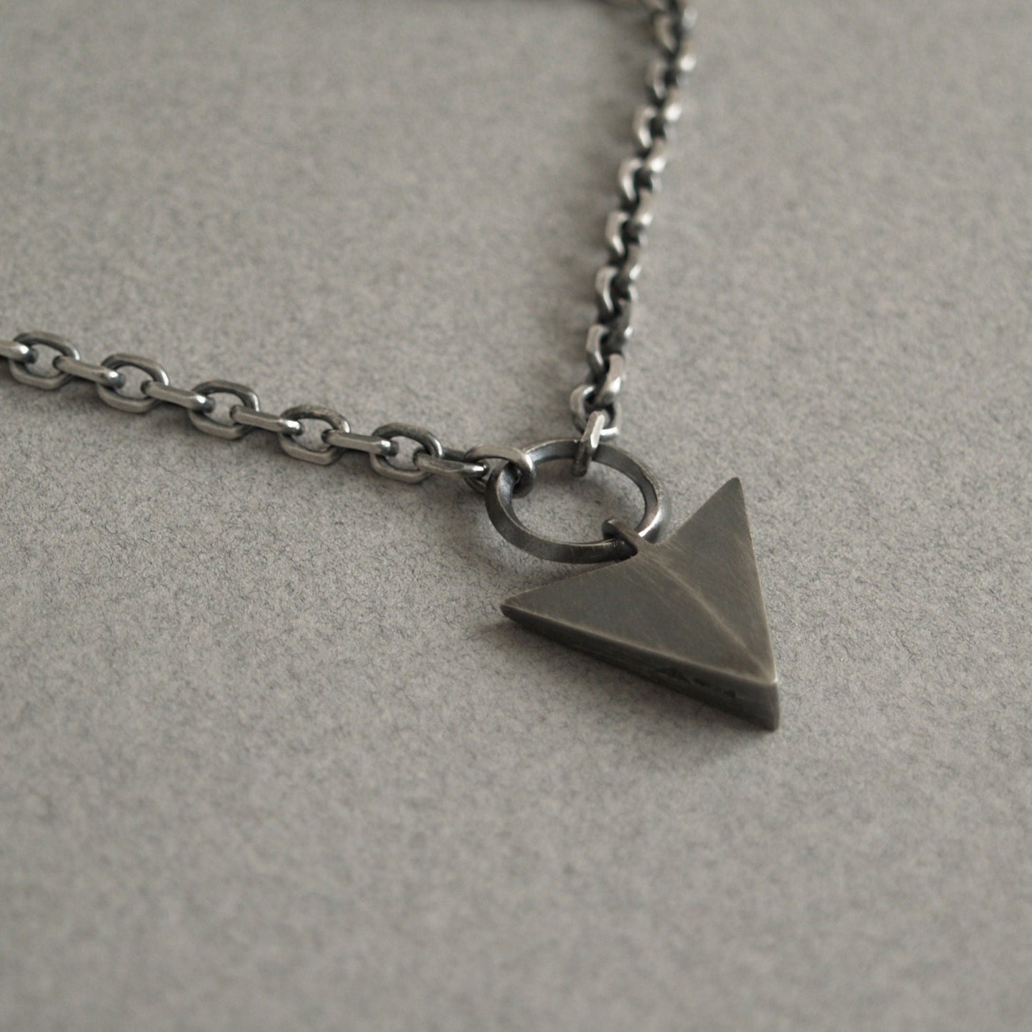 Oxidised or polished solid sterling silver large arrow and loop detail pendant on a diamond cut trace chain