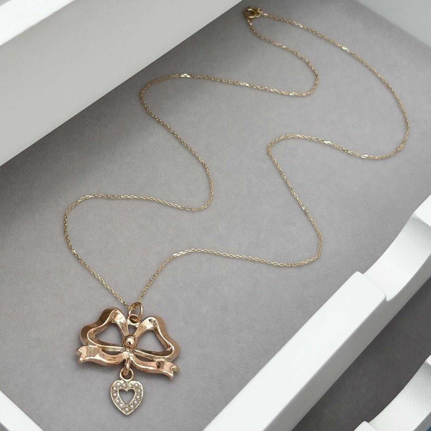 Vintage 9ct rose gold ribbon bow and seed pearl heart pendant on a new fine 0.8mm 9ct yellow gold chain