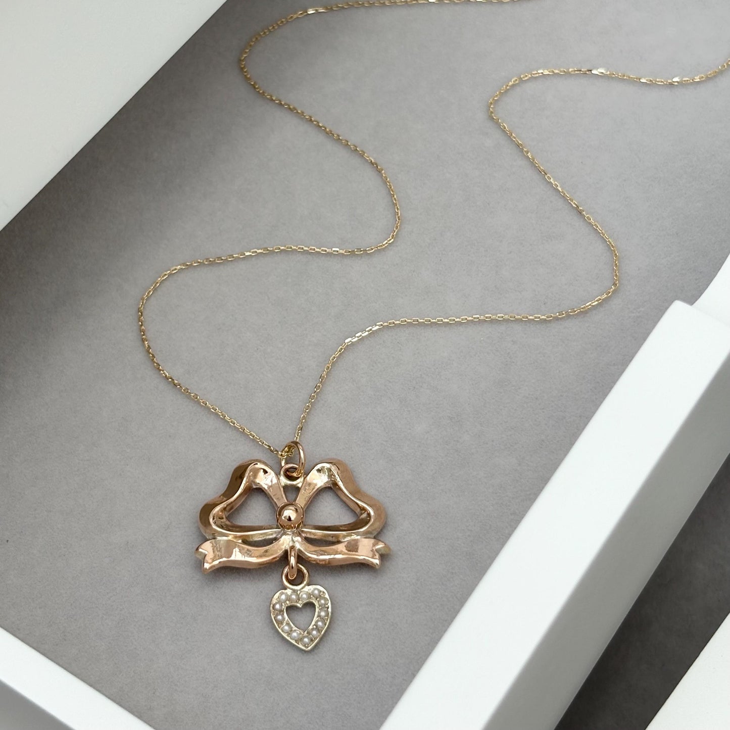 Vintage 9ct rose gold ribbon bow and seed pearl heart pendant on a new fine 0.8mm 9ct yellow gold chain