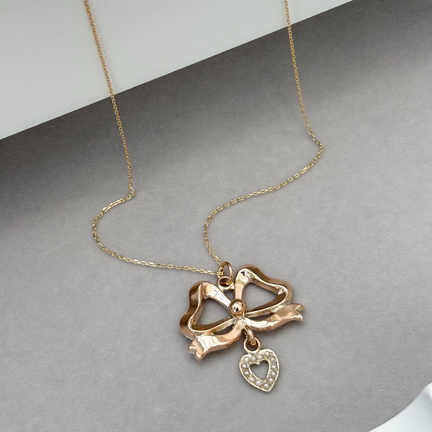 Vintage 9ct rose gold ribbon bow and seed pearl heart pendant on a new fine 0.8mm 9ct yellow gold chain