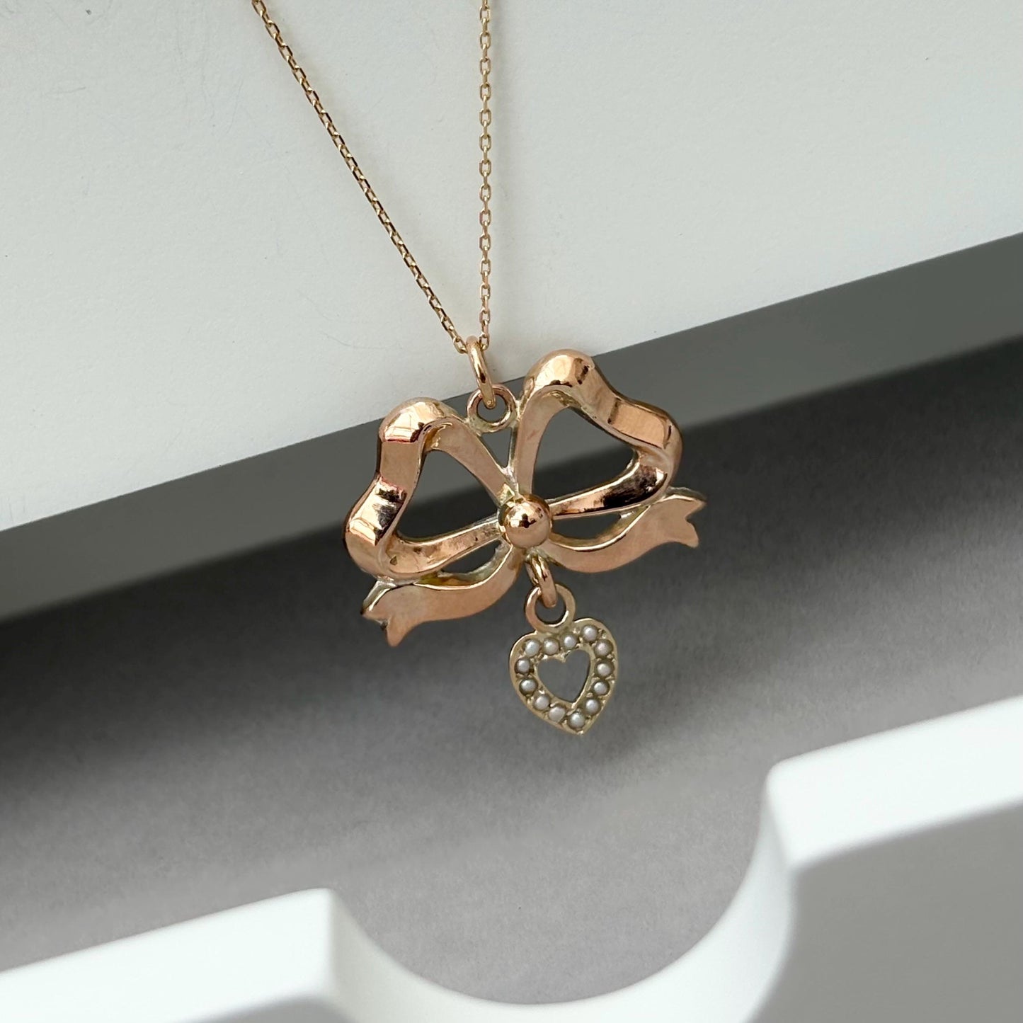 Vintage 9ct rose gold ribbon bow and seed pearl heart pendant on a new fine 0.8mm 9ct yellow gold chain