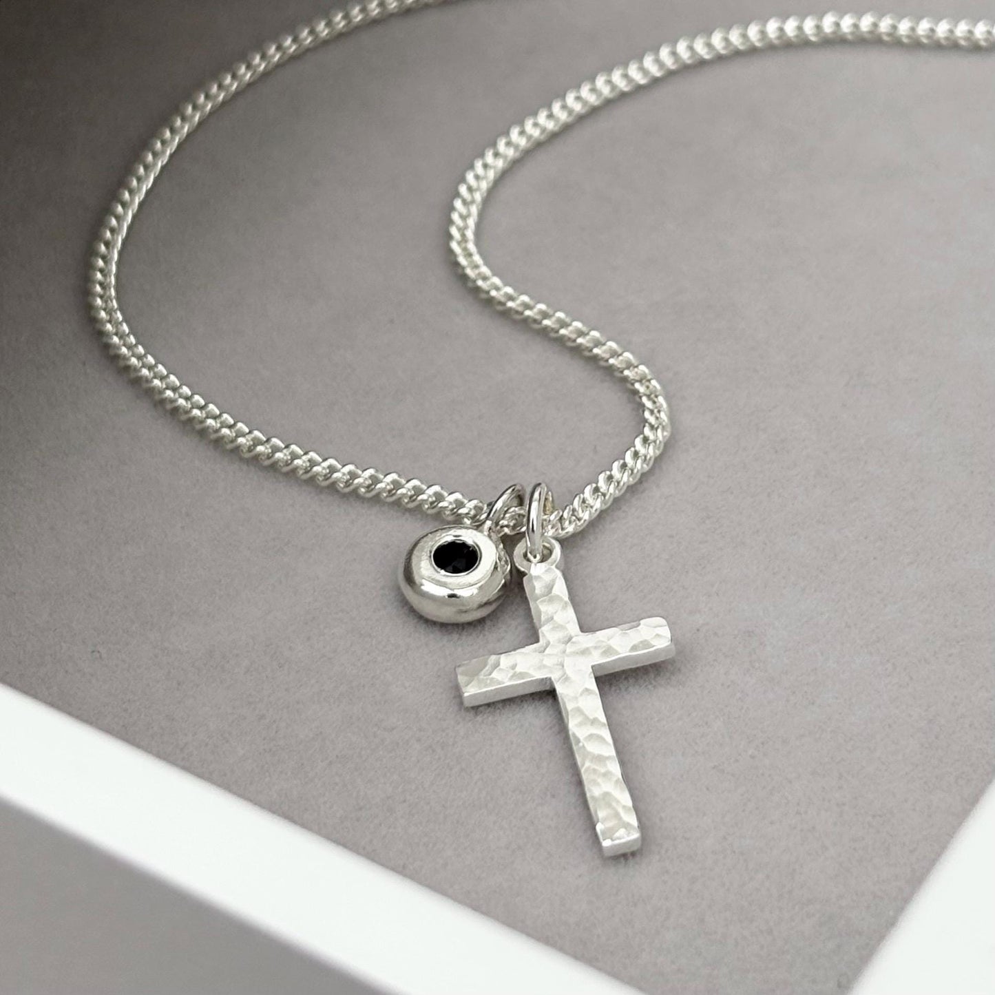 Oxidised or polished small size solid silver hammered cross pendant and black sapphire nugget charm on a curb chain