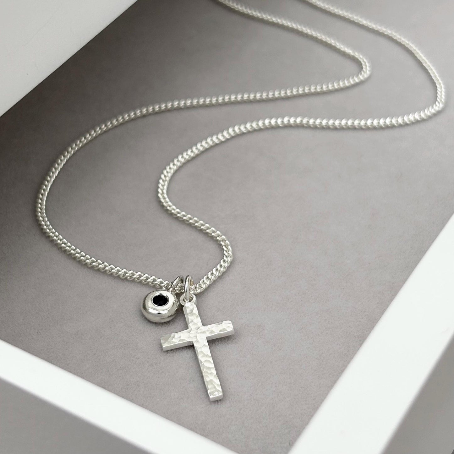 Oxidised or polished small size solid silver hammered cross pendant and black sapphire nugget charm on a curb chain