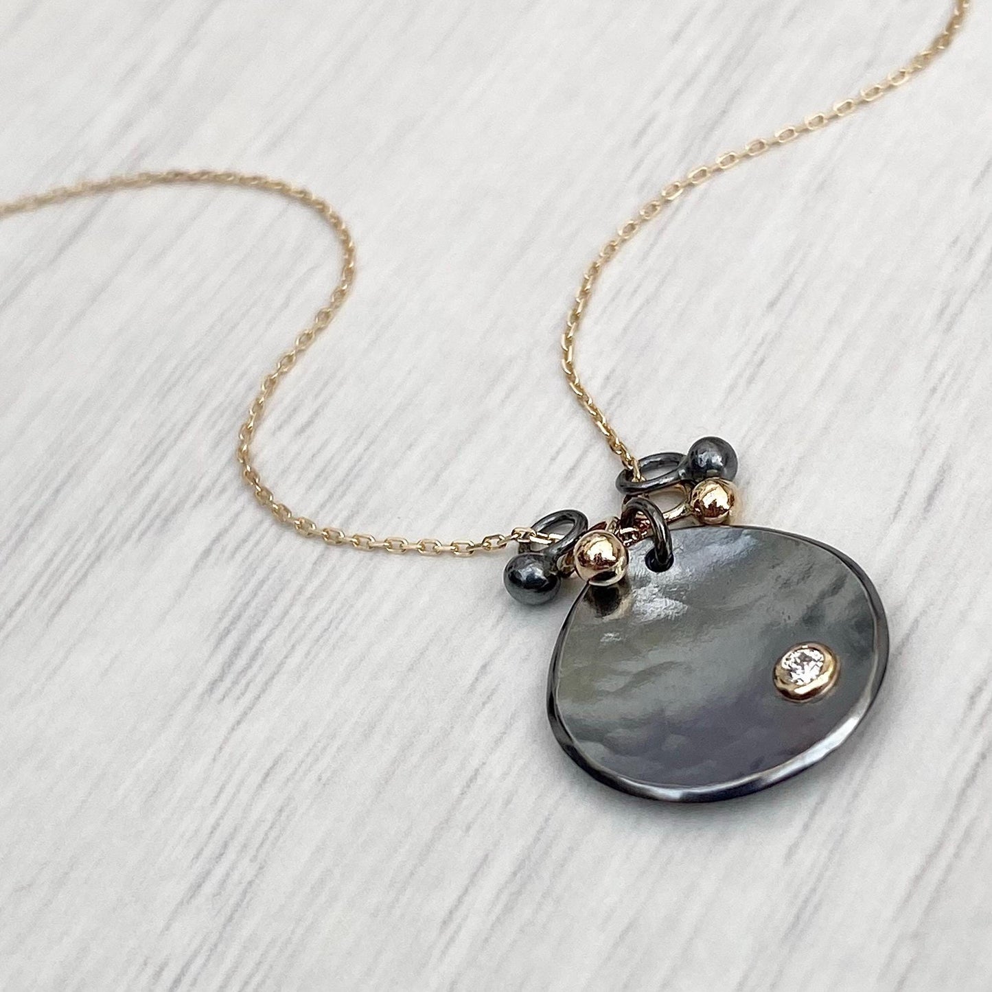 Oxidised solid sterling silver and 9ct yellow gold diamond petal pendant on a fine 9ct yellow gold chain with seed detail